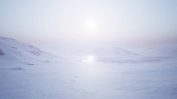 Aerial Landscape of Snowy Mountains and Icy Shores in Antarctica