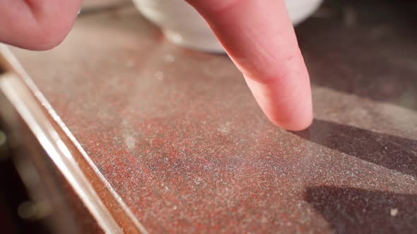 The Finger Runs Along a Lacquered Wooden Surface in a Layer of Dust