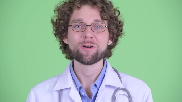 Face of Happy Young Bearded Man Doctor Looking Surprised