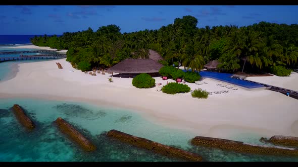 Aerial drone shot tourism of luxury shore beach holiday by blue green lagoon with white sand backgro