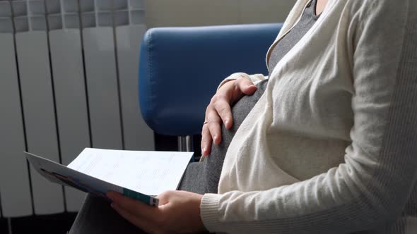 Young Pregnant Woman In Medicine Protective Mask Reading On Couch Waiting For Appointment Medical