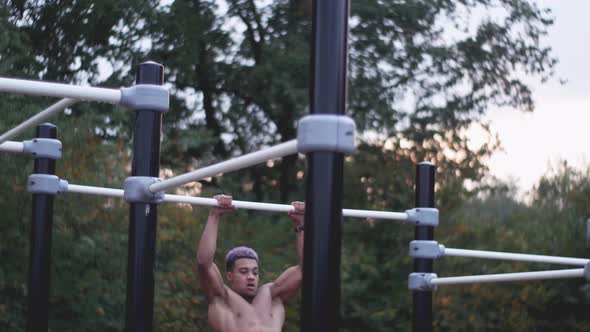 dolly shot of a young ripped man doing muscle ups in an outdoor calisthenics sports park
