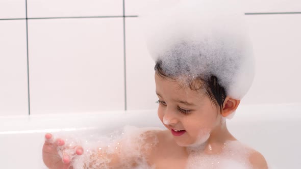 Three Year Old Child with Big Brown Eyes Is Sitting in a White Bathroom