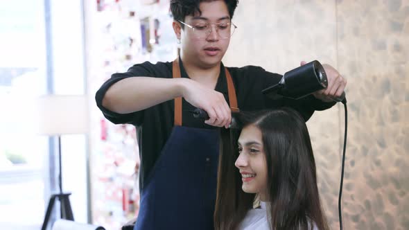 Hairdresser Using Hairdryer on Customer