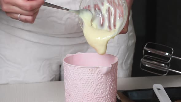 A Woman Adds Condensed Milk To A Container.