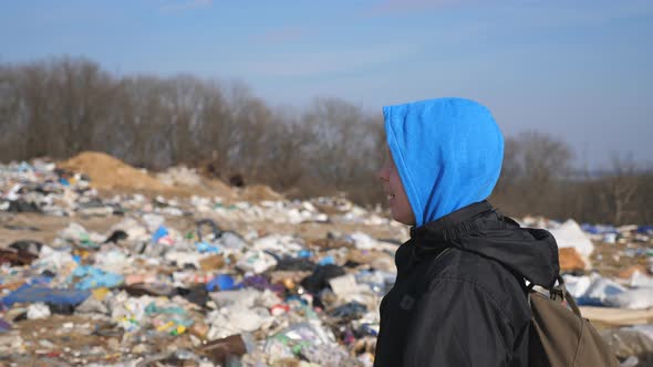 Close Up of Little Sad Boy with Backpack Walks Along Road To School Against the Blurred Background