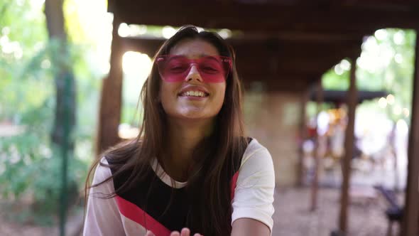 Beautiful Young Woman on Vacation in Pink Glasses