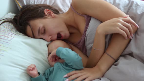 Young Mother and Her Infant Baby Having Fun Playing in Bed Morning Cuddling