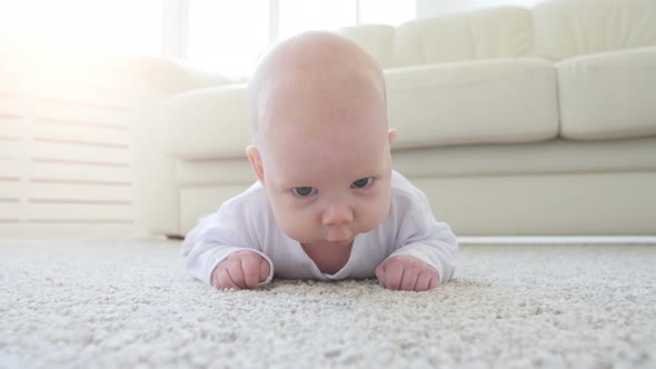 Cute Funny Baby Lying on a Beige Carpet