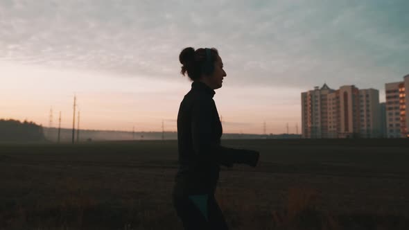 Sporty Female Jogger Is Running and Training Outside at the Nature. Athletic Woman Is Running During