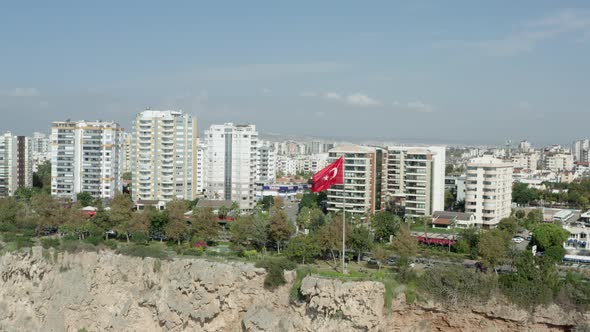 Drone Video Flag of Turkey Evolving on a Rock in a City