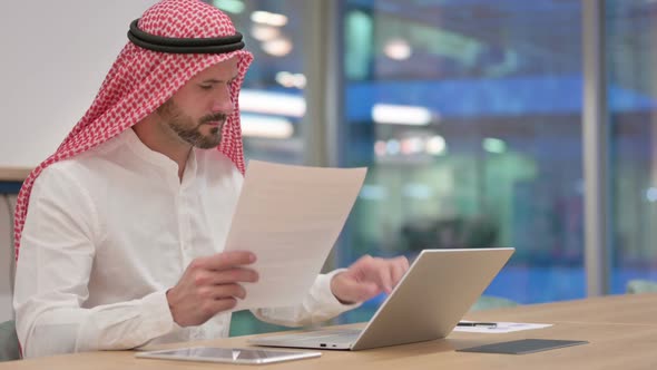 Arab Businessman Working on Laptop and Documents