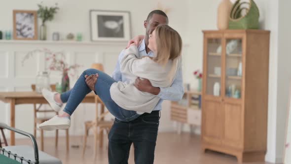 Loving African Man Holding Caucasian Woman in Arms and Swirling