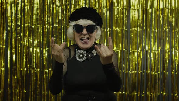 Excited Positive Senior Woman Showing Rock and Roll Gesture and Sincerely Smiling, Showing Tongue