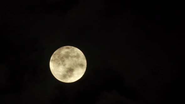 Timelapse of how the full moon rises from behind the clouds. During the shot there are clouds that c