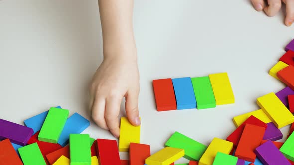 Girl Plays with Colorful Blocks.