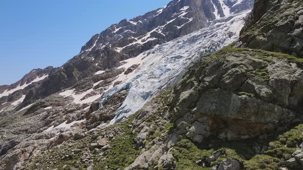 Glacier Covered with Stone Rocks Deep Cracks and Small Waterfalls