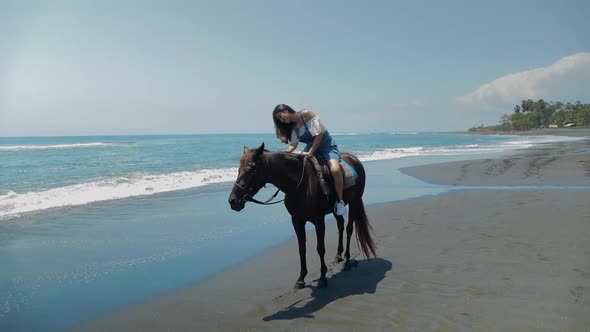 Cute Chinese Teenager Rides a Horse On The Beach In Bali