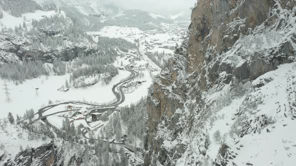 Aerial of snow covered mountain ridge with a small Swiss town in the background