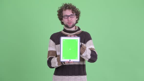 Happy Young Bearded Man Talking While Showing Digital Tablet