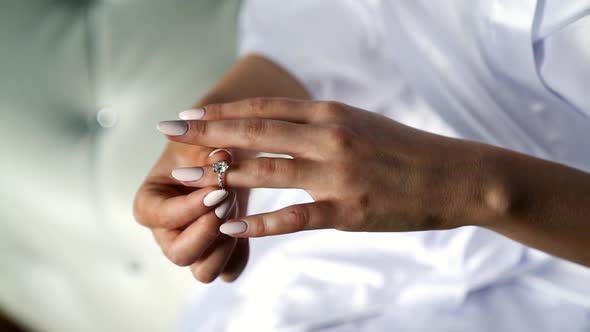 Close Up View of Morning Bride Puts a Wedding Ring on Her Finger