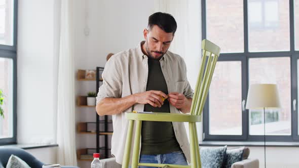 Man with Ruler Measuring Old Wooden Chair at Home