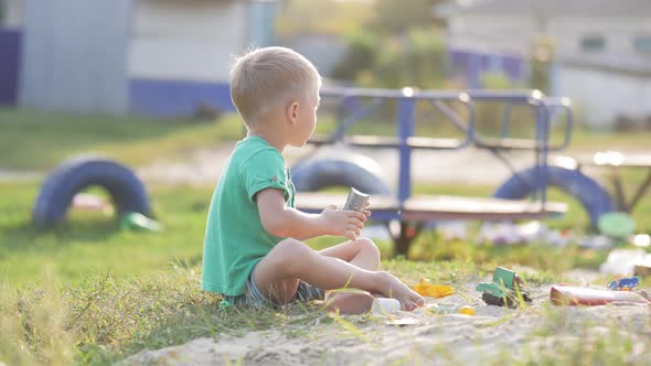 Boy Plays Sand Toys Outdoors