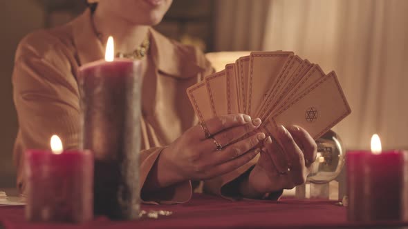 Woman Taking Card from Pack of Tarot Cards at Fortune Teller