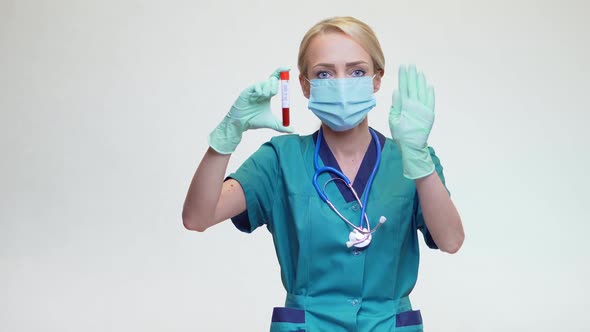 Medical Doctor Nurse Woman Wearing Protective Mask and Gloves - Holding COVID-19 Blood Test