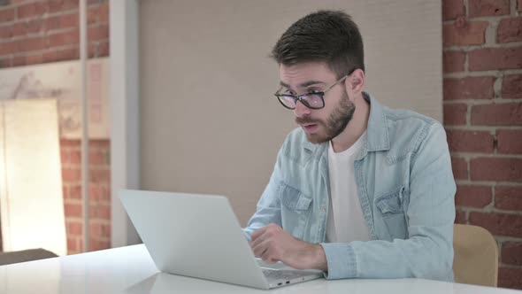 Ambitious Male Designer Celebrating Success on Laptop