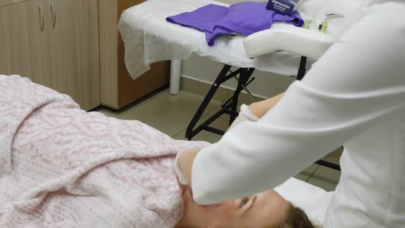 A Masseur Gives a Woman a Professional Facial Massage