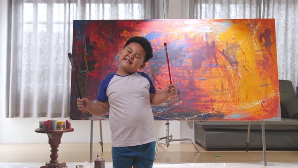 Little Boy Holding Brush And Looks At The Camera With A Smile