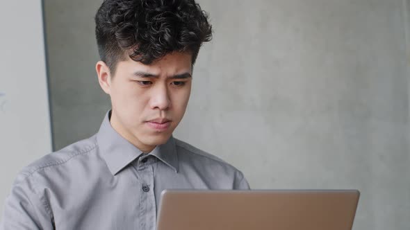 Portrait of Pensive Asian Business Man Working with Laptop Solves Application Problems Error in