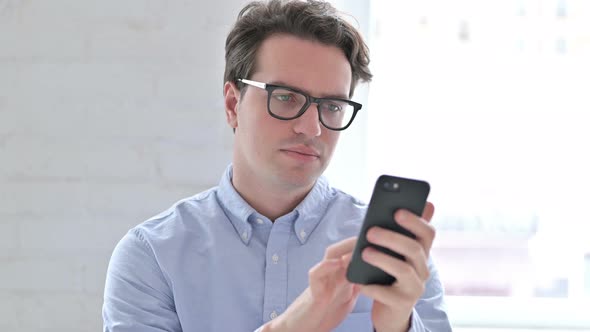 Portrait of Relaxed Young Man Using Smartphone