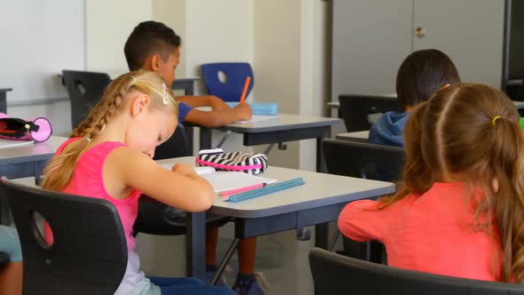 Multi-ethnic schoolkids studying at desk in a classroom at school 4k