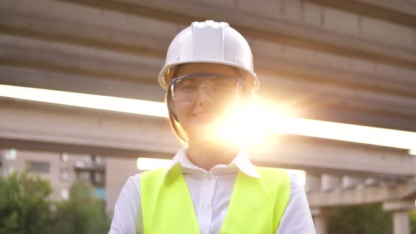 Portrait of Young Builder Woman Wearing Safety Helmet Looking at Camera While Standing at