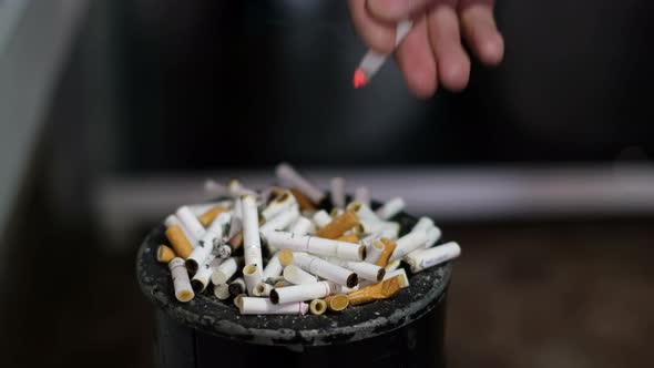 The Man Throws the Cigarette Butt Into the Ashtray