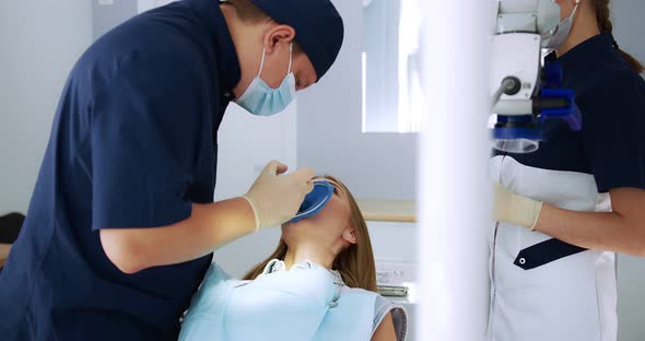 A Male Dentist Performs a Procedure for Removing a Cofferdam to Patient