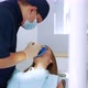 A Male Dentist Performs a Procedure for Removing a Cofferdam to Patient - VideoHive Item for Sale
