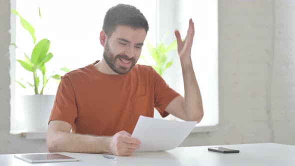 Happy Young Man Celebrating While Reading Documents