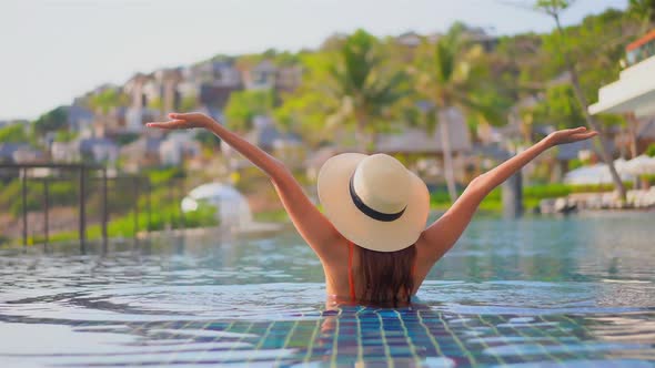 Young asian woman enjoy around outdoor swimming pool for leisure