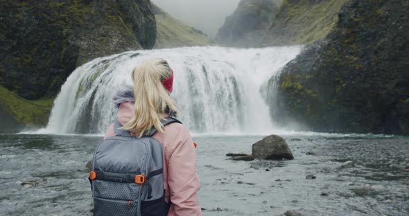 Iceland Woman with Backpack Enjoying Stjornarfoss Waterfall Near Kirkjubaejarklaustur