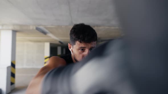 Fighter Practicing Punches on Boxing Bag at the Parking Zone Closeup