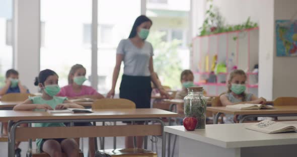 Female Teacher Wearing Face Mask at School Teaching Children at School Classroom