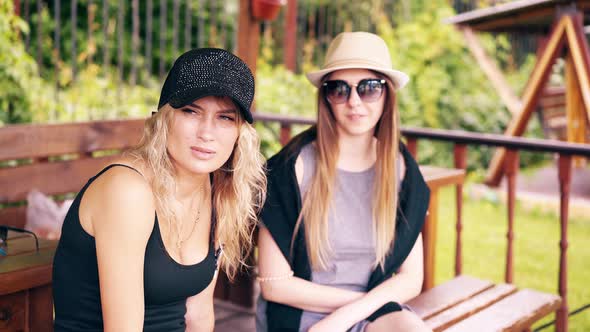 Two Pretty Girls Sit in a Summer House, Smile