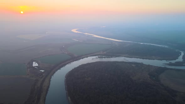 Aerial View of Wide River Flowing Quietly in Rural Countryside in Autumn Evening