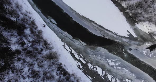 Frozen River In Snowy Landscape With Trees - Drone Shot, Rotating