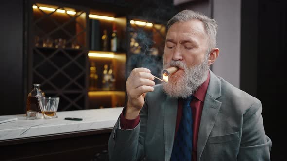 Bearded Mature Businessman Wearing Suit Lighting Expensive Cuban Cigar Smoking at Cabinet Slow