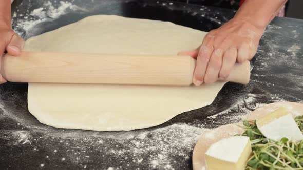 Process of making traditional italian pizza. Female hands working with dough for pizza