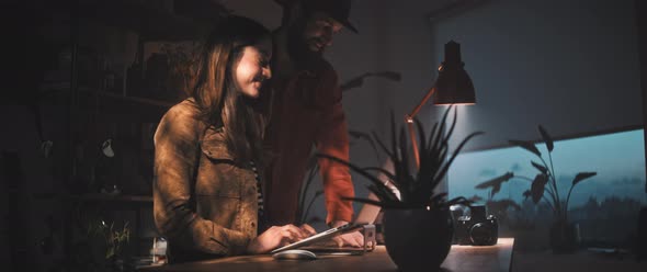 Man and woman smile while working together